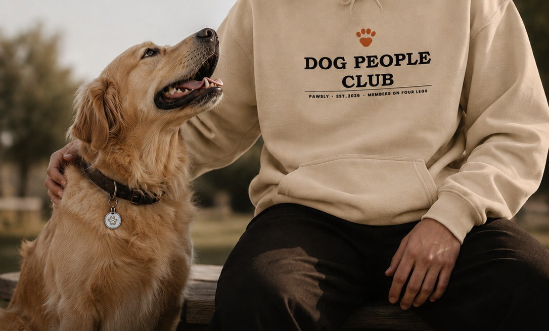 Man sitting with his golden retriever, wearing the Dog People Club Hoodie in Sand